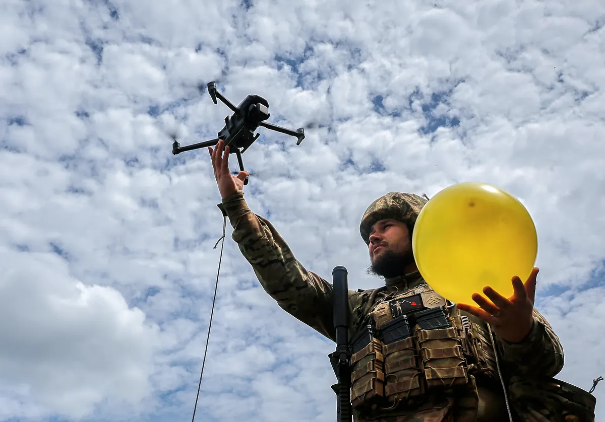 A Ukrainian serviceman lifts a drone attached to a balloon for target practice during anti-drone training at an undisclosed location near the frontline in the Kharkiv region, northeastern Ukraine, 30 May 2025. Photo: EPA-EFE/SERGEY KOZLOV