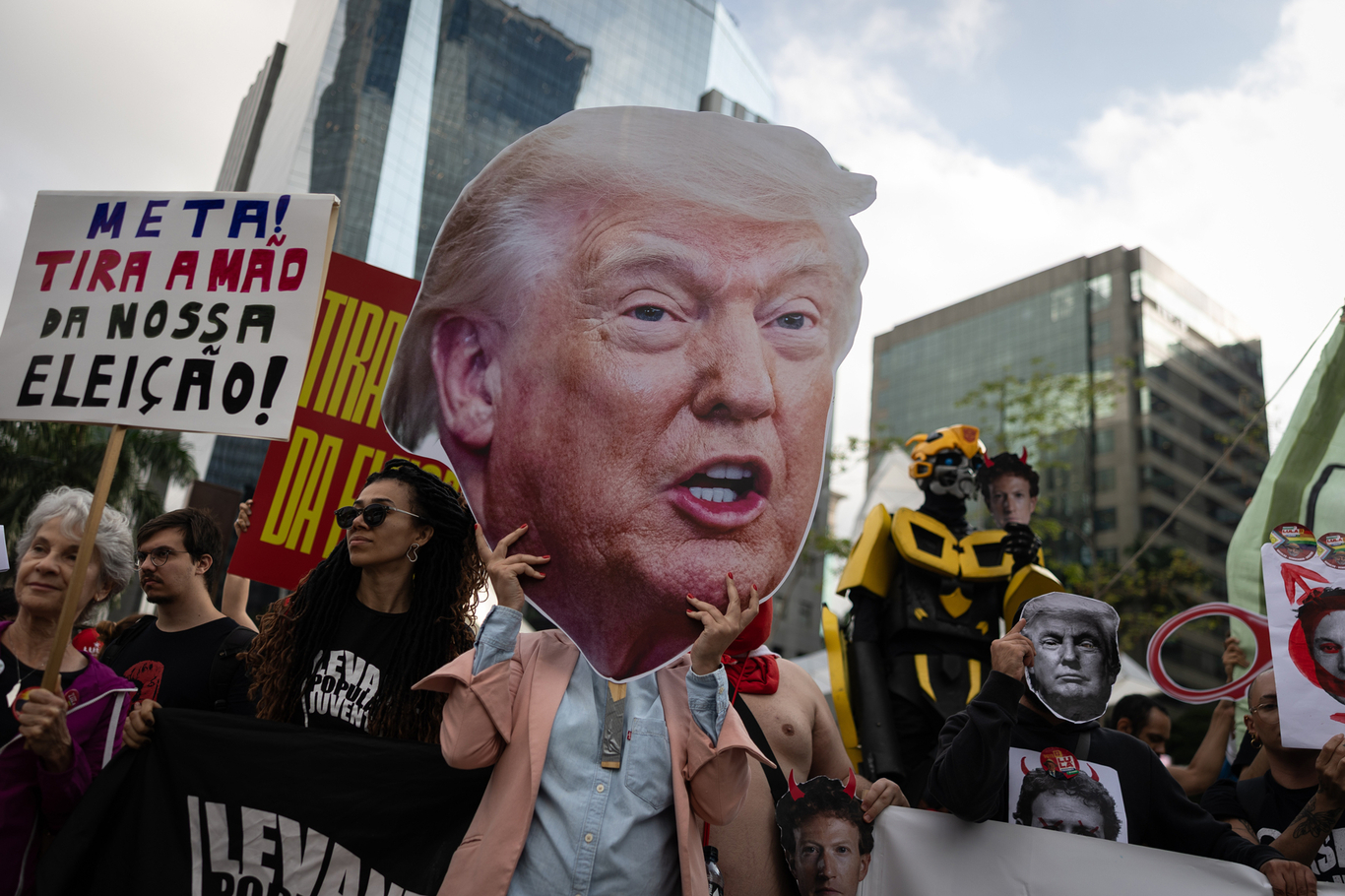 Участник акции держит портрет Дональда Трампа перед офисом компании Meta во время демонстрации против возможного вмешательства платформы в выборы. Сан-Паулу, Бразилия. 19 октября 2026 года. Фото: Isaac Fontana / EPA