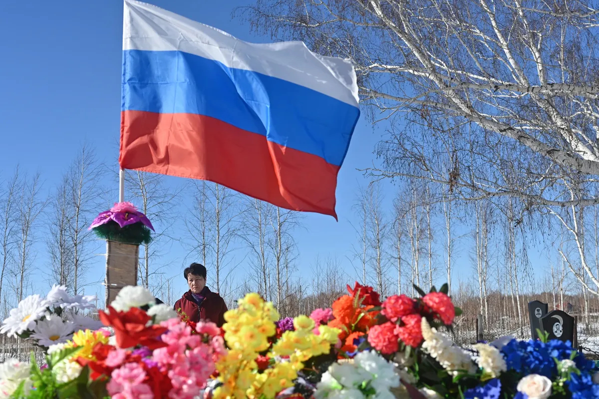Nurzia beside her son’s grave. Rishat is buried next to his father. Photo: Yevgeny Kulikov