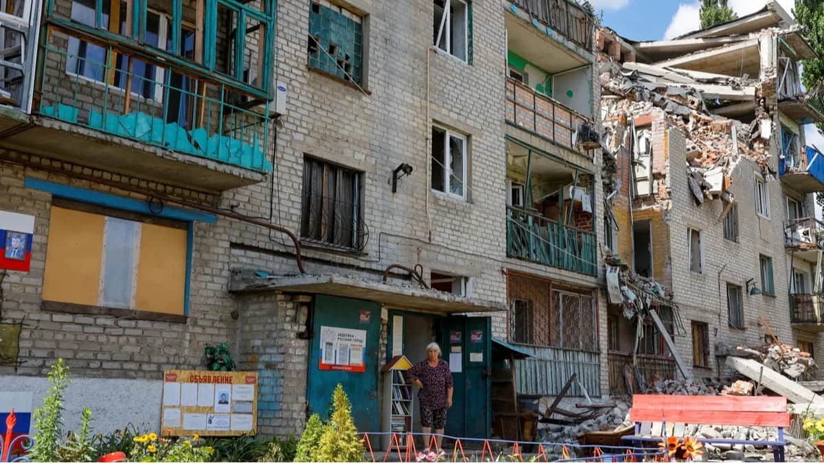 Местная жительница у многоквартирного дома, повреждённого в ходе боевых действий, Авдеевка, Донецкая область, Украина, 12 августа 2024 года. Фото: Александр Ермоченко / Reuters / Scanpix / LETA