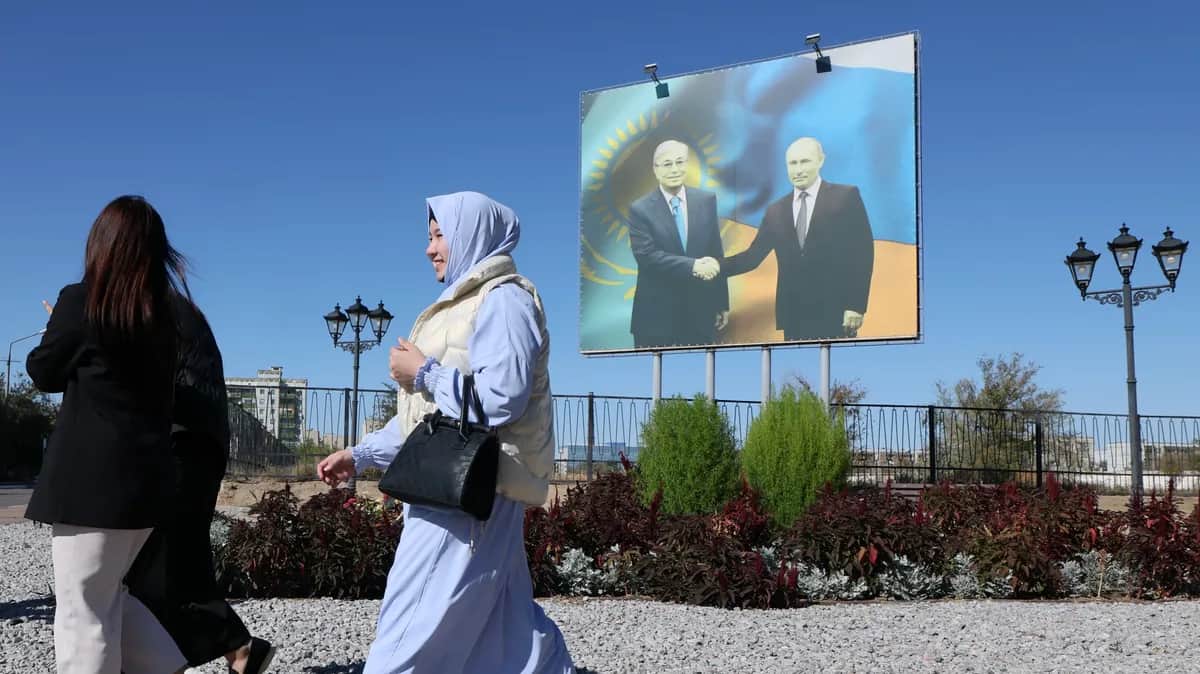 A woman walks past a billboard featuring Vladimir Putin and Kazakhstan’s President Kassym-Jomart Tokayev in the city of Baikonur, Kazakhstan, 9 September 2024. Photo: EPA-EFE / MAXIM SHIPENKOV