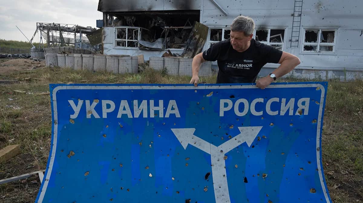 Мужчина несет дорожный знак в Судже, Курская область, Россия, 16 августа 2024 года. Фото: AP / Scanpix / LETA