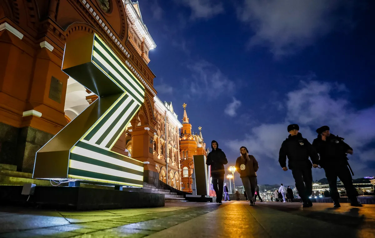 Police officers walk past an illuminated letter Z installation in support of the Russian army near the Kremlin, Moscow, 25 March 2023. Photo: EPA/YURI KOCHETKOV