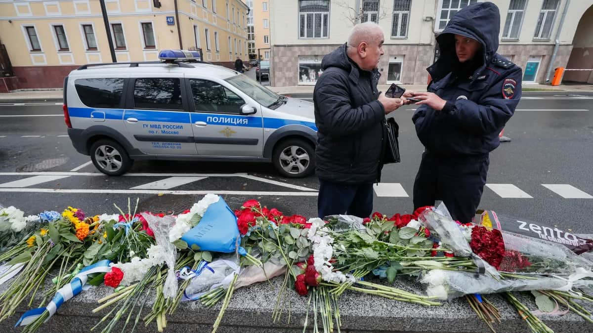 A police officer checks a man’s documents as he leaves flowers outside Israel’s Moscow embassy. Photo: EPA-EFE/YURI KOCHETKOV
