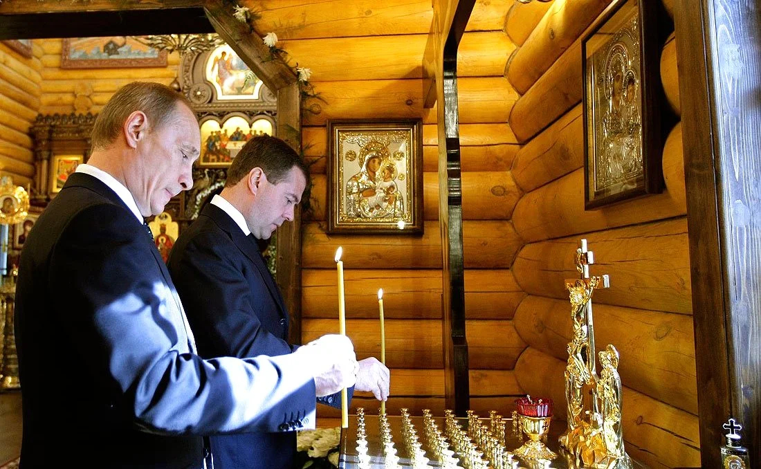 Владимир Путин и Дмитрий Медведев ставят свечи в часовне на территории резиденции главы государства в память о погибших в катастрофе под Смоленском. Фото: <a href="https://commons.wikimedia.org/w/index.php?curid=9974118">Wikimedia Commons</a>, CC BY 4.0