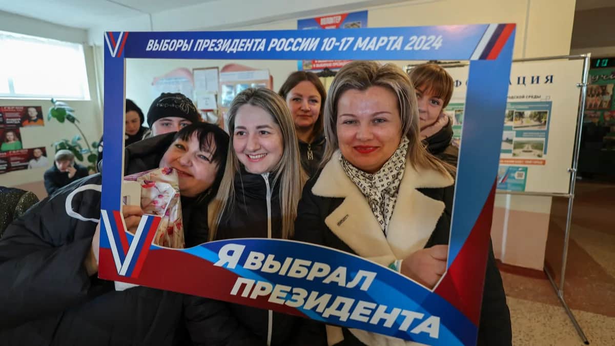 Пришедшие на избирательном участке в Макеевке Донецкой области делают общее фото с акцией «Я выбрал президента», 17 марта 2024 года. Фото: Alessandro Guerra / EPA-EFE