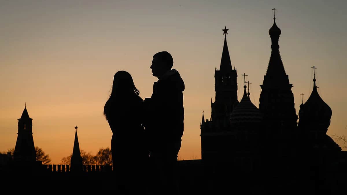 Пара стоит перед Московским Кремлем в Москве, Россия, 23 марта 2022 года. Фото: Юрий Кочетков / EPA-EFE