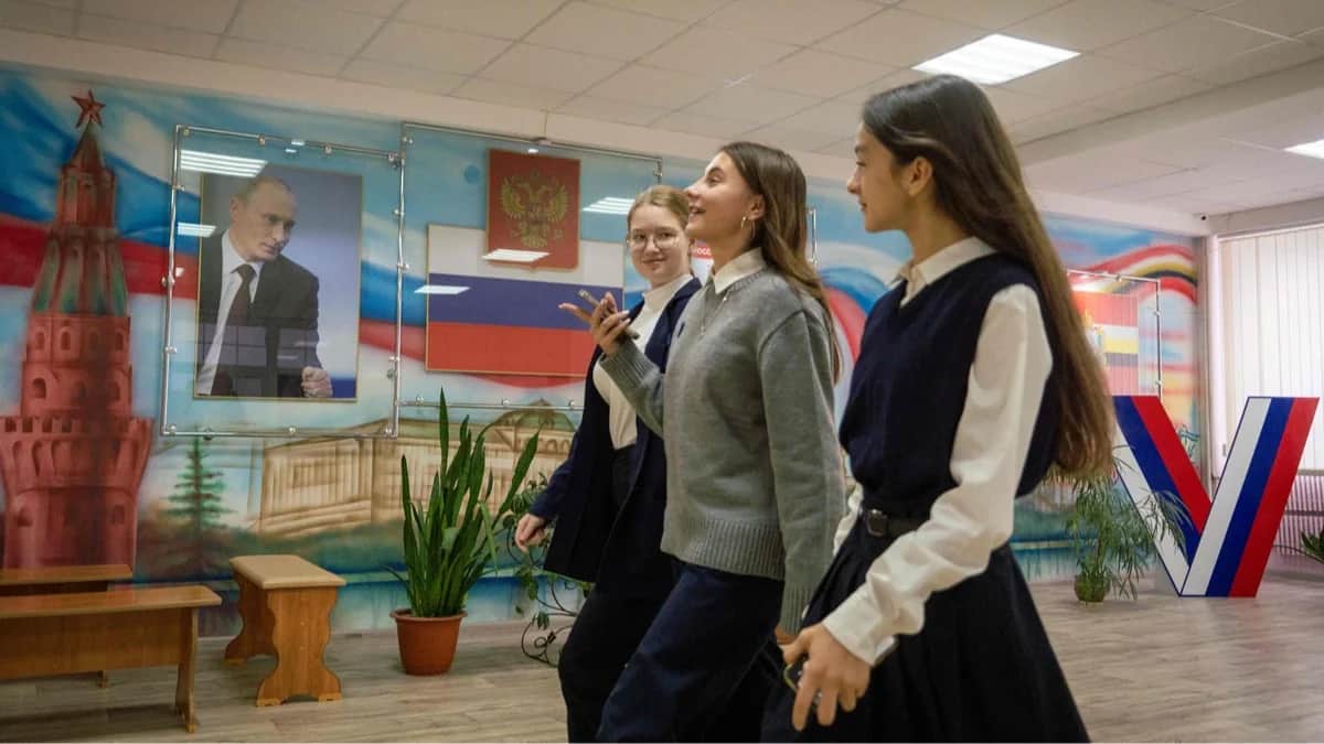 Школьники идут по коридору школы, украшенной портретом Владимира Путина и триколором, Курск, 17 октября 2024 года. Фото: Андрей Бородулин / AFP / Scanpix / LETA