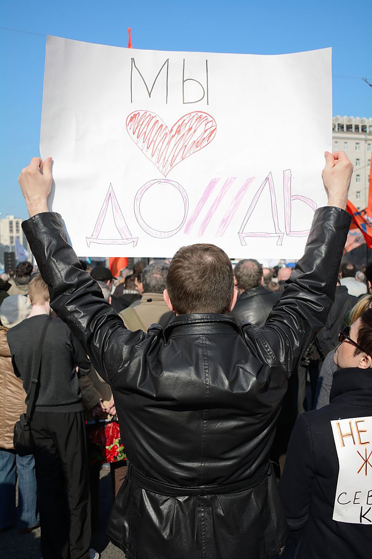 Мужчина с плакатом Мы любим Дождь. Фото: Dhārmikatva / Wikimedia