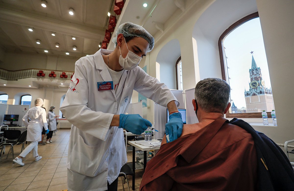 Мужчина получает прививку российской вакциной «Спутник V» от COVID-19 в пункте вакцинации в Государственном универмаге «ГУМ» в Москве, Россия, 1 ноября 2021 года. Фото: Юрий Кочетков / EPA-EFE