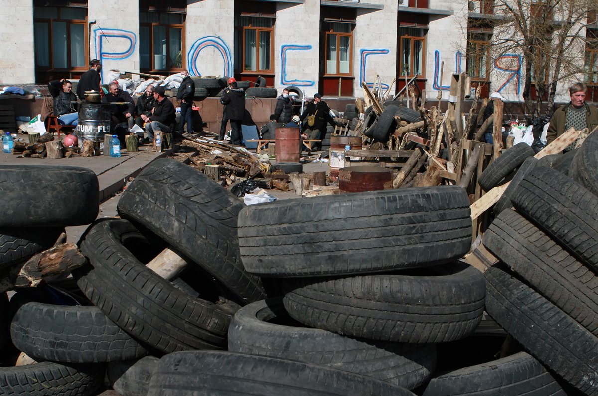 Пророссийские демонстранты отдыхают возле баррикады перед захваченным зданием областной администрации в Донецке, Украина, 8 апреля 2014 года. Фото: Photomig / EPA