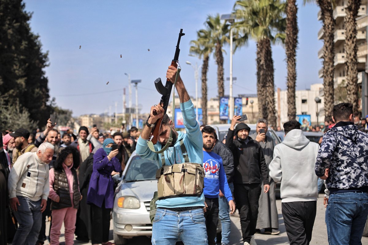 Вооружённый сириец стреляет в воздух на похоронах силовика, убитого в результате нападения сторонников бывшего президента Башара Асада, провинция Хама, 9 марта 2025 года. Фото: Bilal Al Hammoud / EPA