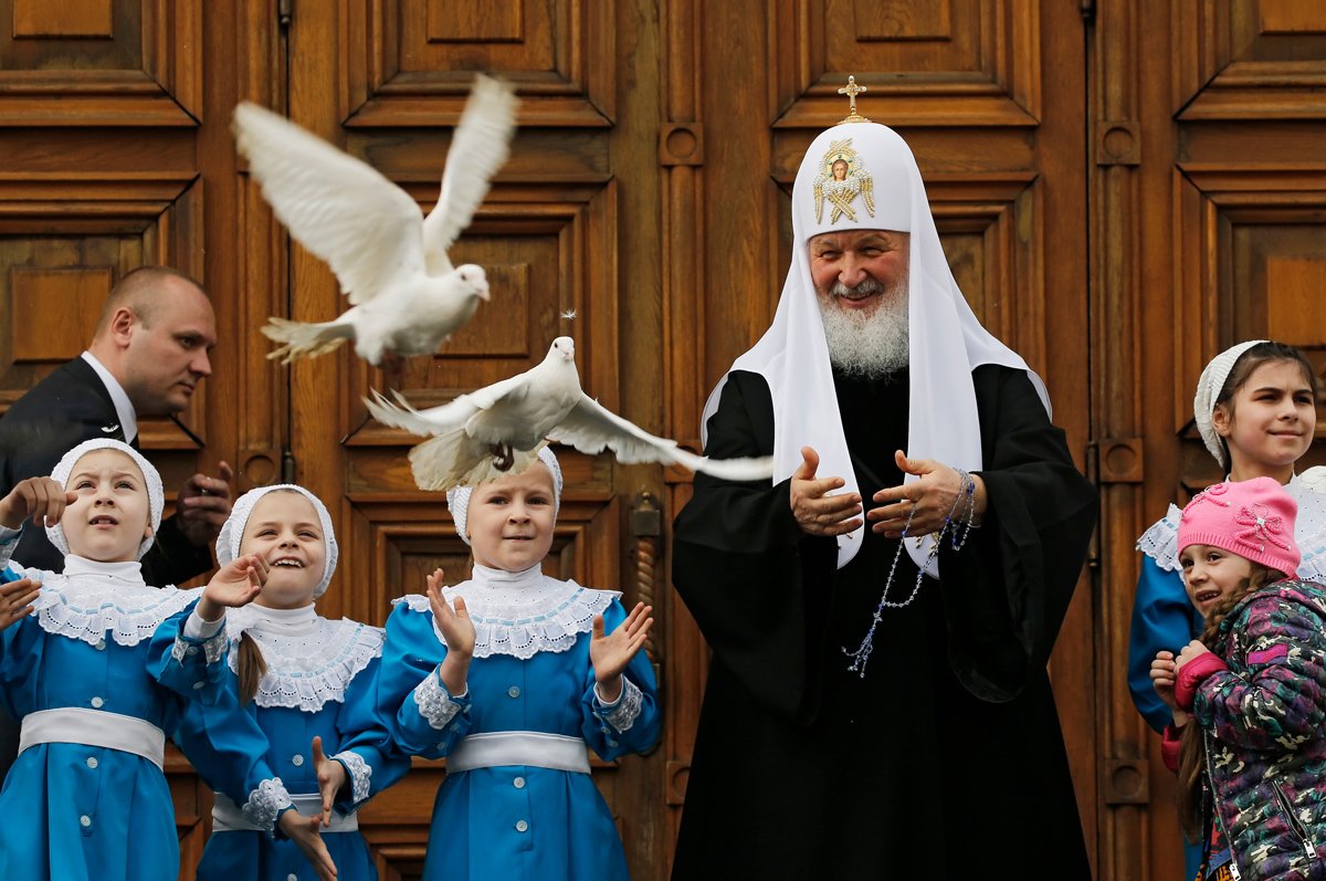 Патриарх Кирилл (справа) с детьми выпускает голубей в честь праздника Благовещения в Московском Кремле, 7 апреля 2017 года. Фото: Юрий Кочетков / EPA-EFE