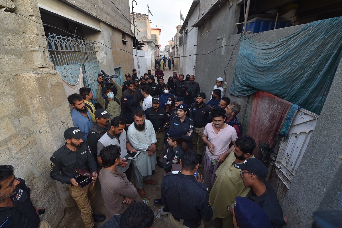 Сотрудники пакистанской полиции проверяют документы у людей во время рейда по выявлению незарегистрированных мигрантов в Карачи, Пакистан, 17 ноября 2023 года. Фото: Shahzaib Akber / EPA