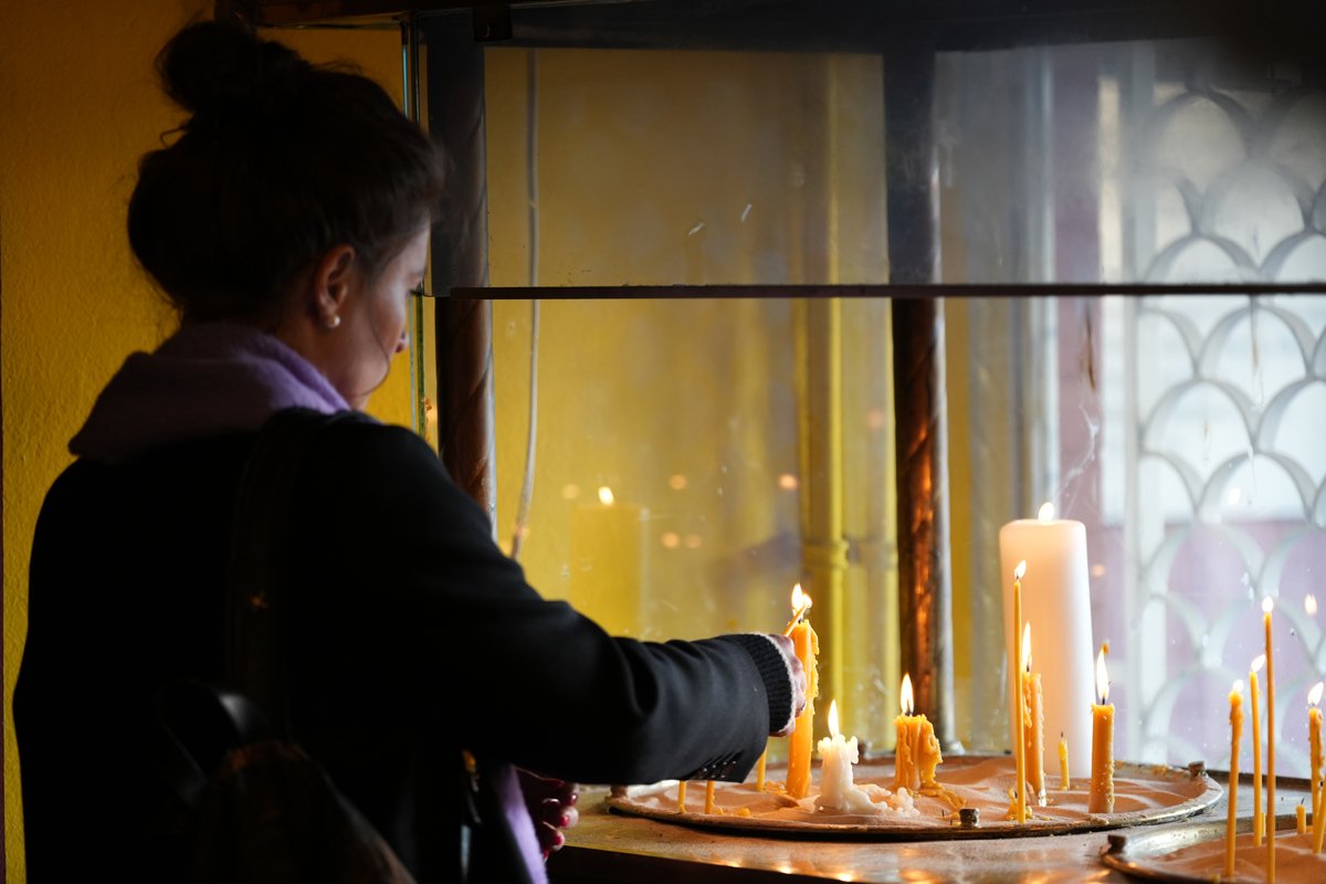Мария Певчих ставит свечку на панихиде. Фото: voleemor / «Новая газета Европа»